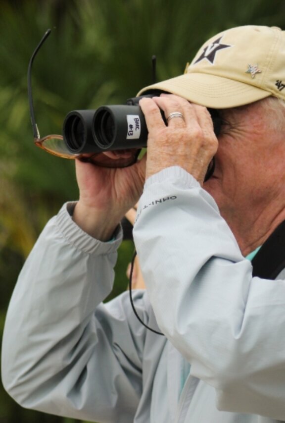 man with binoculars looking at birds